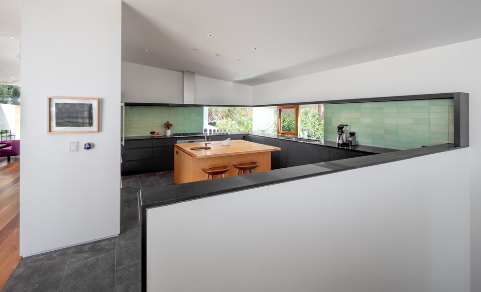 Foto di una cucina minimal chiusa e di medie dimensioni con ante lisce, ante nere, top in granito, paraspruzzi verde, paraspruzzi con piastrelle di cemento, elettrodomestici in acciaio inossidabile, pavimento in ardesia, pavimento grigio e top nero