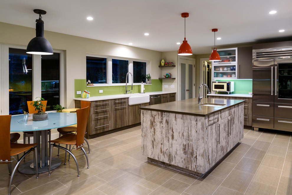 Photo of a contemporary u-shaped kitchen/diner in Jacksonville with a belfast sink, flat-panel cabinets, brown cabinets, green splashback, stainless steel appliances, an island, grey floors and multicoloured worktops.