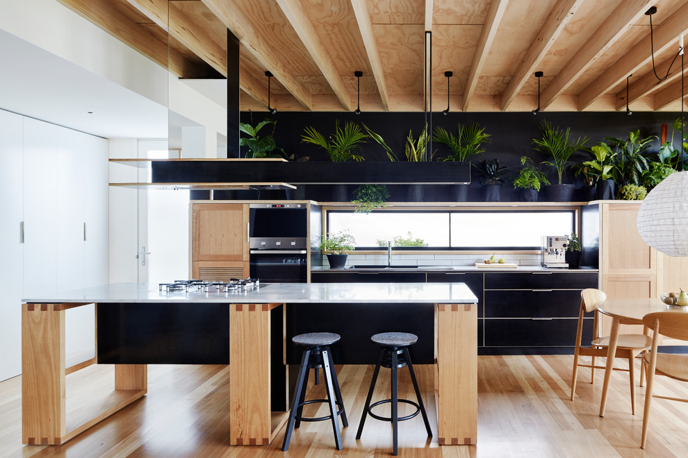 Offene, Kleine Moderne Küche mit Marmor-Arbeitsplatte, Küchenrückwand in Weiß, Rückwand aus Metrofliesen, Küchengeräten aus Edelstahl, hellem Holzboden und Kücheninsel in Melbourne