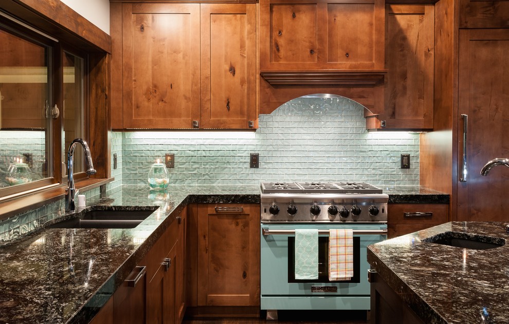 Esempio di una grande cucina con lavello a doppia vasca, ante in legno scuro, top in granito, paraspruzzi blu e paraspruzzi con piastrelle di vetro