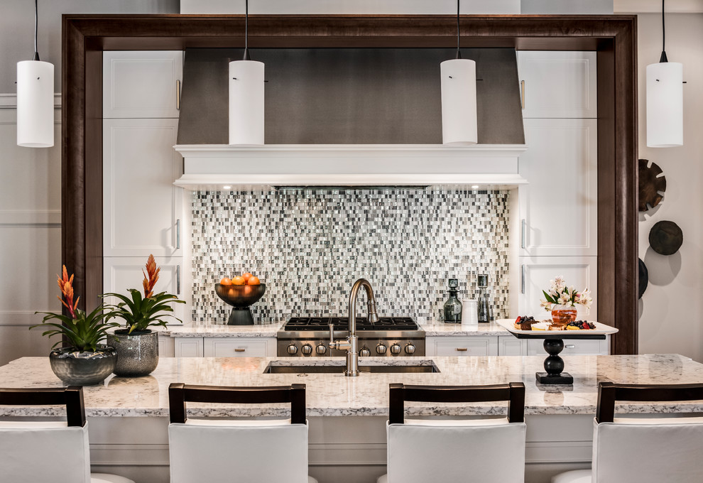 Inspiration for a mid-sized l-shaped medium tone wood floor and brown floor open concept kitchen remodel in Miami with an undermount sink, raised-panel cabinets, brown cabinets, marble countertops, multicolored backsplash, mosaic tile backsplash, stainless steel appliances, an island and multicolored countertops