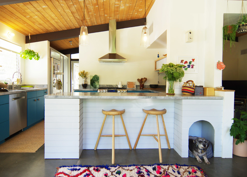 Kitchen - mid-sized 1960s u-shaped concrete floor and gray floor kitchen idea in Los Angeles with flat-panel cabinets, blue cabinets, stainless steel appliances, a peninsula, marble countertops and window backsplash