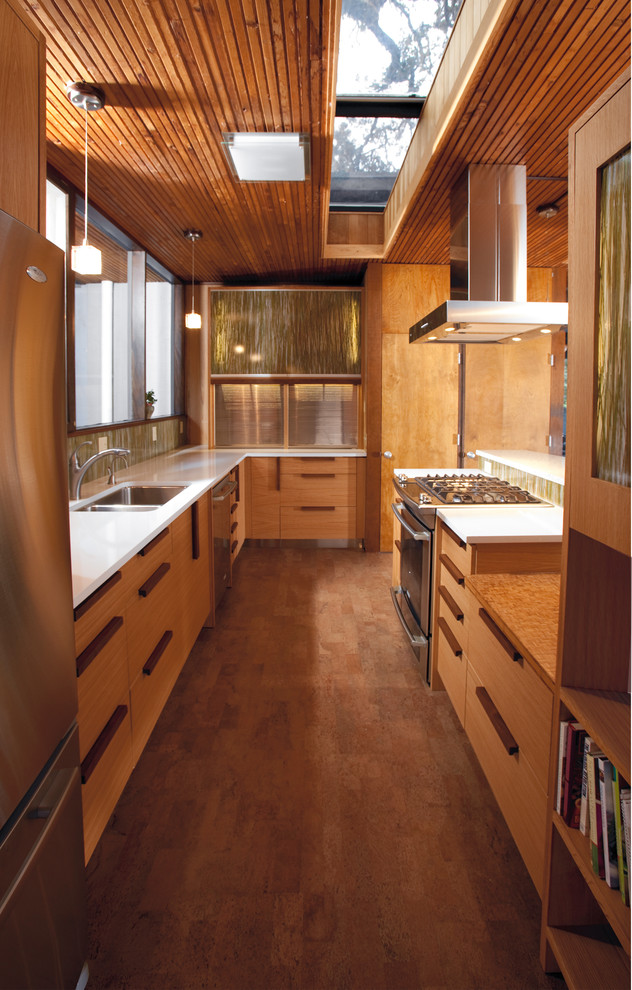 Inspiration for a large midcentury galley enclosed kitchen in Other with a submerged sink, engineered stone countertops, cork flooring, flat-panel cabinets, light wood cabinets, multi-coloured splashback, matchstick tiled splashback, stainless steel appliances and a breakfast bar.