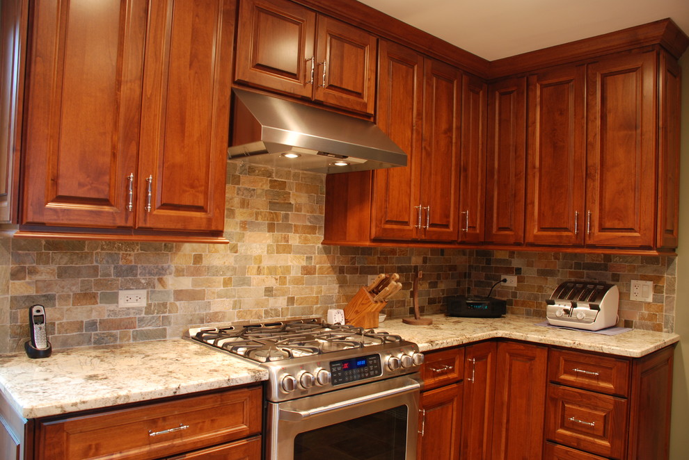 Cette image montre une cuisine américaine chalet en L et bois brun de taille moyenne avec un évier 2 bacs, un placard avec porte à panneau surélevé, un électroménager en acier inoxydable et une péninsule.