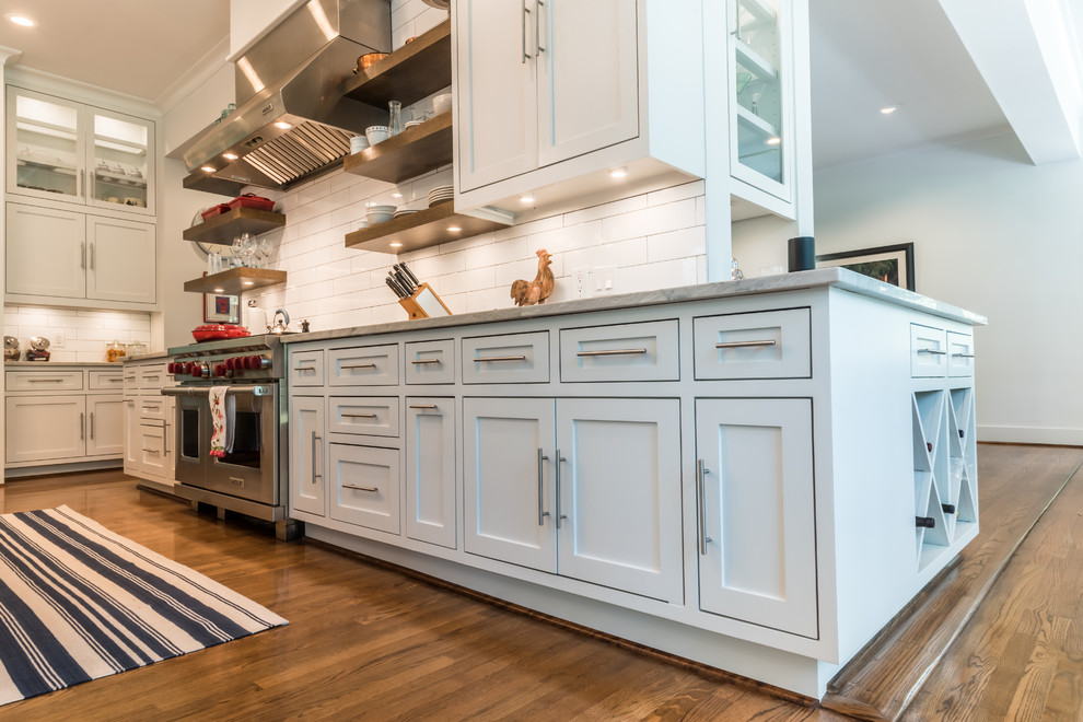 Example of a large country l-shaped dark wood floor and brown floor eat-in kitchen design in Houston with an undermount sink, shaker cabinets, gray cabinets, quartzite countertops, white backsplash, subway tile backsplash, stainless steel appliances, an island and gray countertops