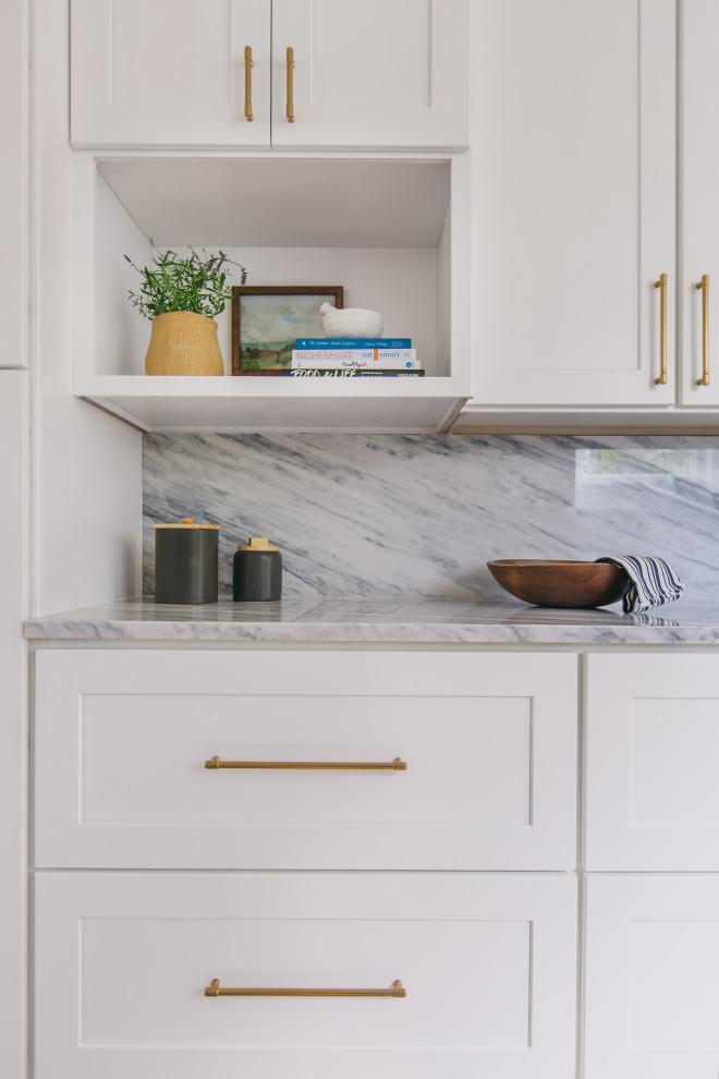 Bild på ett amerikanskt grå grått kök, med en rustik diskho, skåp i shakerstil, vita skåp, marmorbänkskiva, grått stänkskydd, stänkskydd i marmor, rostfria vitvaror, ljust trägolv och beiget golv