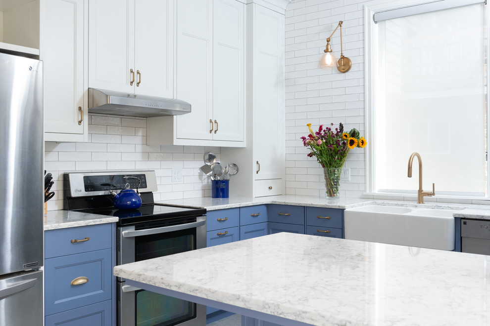 Inspiration for a mid-sized transitional u-shaped porcelain tile and gray floor kitchen pantry remodel in Ottawa with a farmhouse sink, shaker cabinets, blue cabinets, quartz countertops, white backsplash, ceramic backsplash, stainless steel appliances, a peninsula and gray countertops