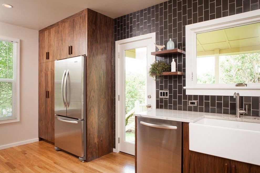Enclosed kitchen - contemporary enclosed kitchen idea in Portland with a farmhouse sink, flat-panel cabinets, dark wood cabinets, quartzite countertops, black backsplash, ceramic backsplash and stainless steel appliances