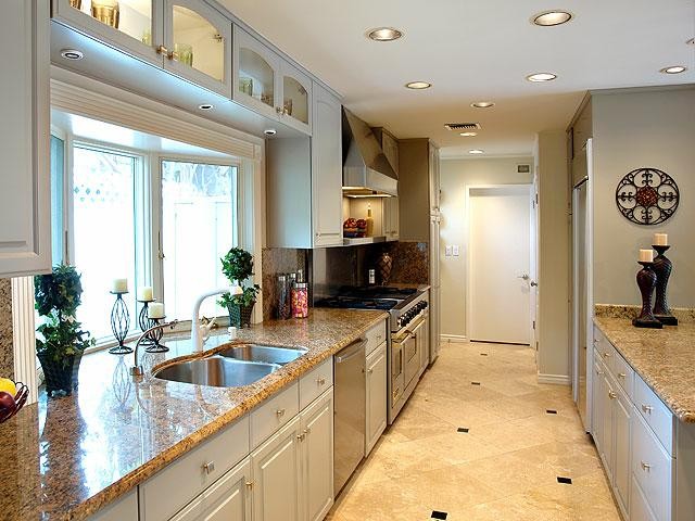 Modern inredning av ett avskilt, litet kök, med en dubbel diskho, grå skåp, bänkskiva i kvarts, beige stänkskydd, stänkskydd i sten, rostfria vitvaror och klinkergolv i keramik