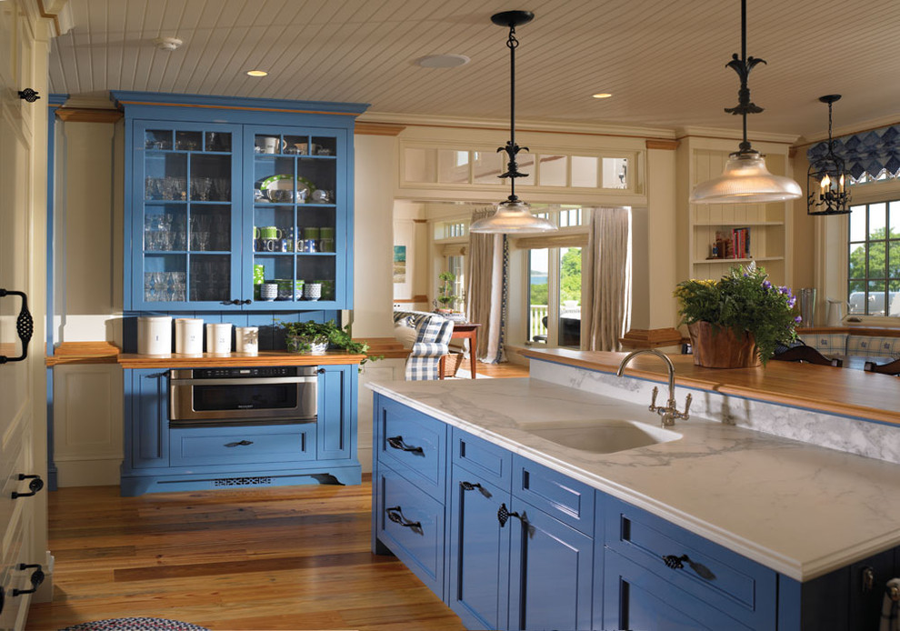 Idéer för ett stort klassiskt kök, med en integrerad diskho, luckor med infälld panel, blå skåp, marmorbänkskiva, integrerade vitvaror, mellanmörkt trägolv och en köksö