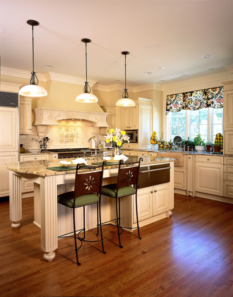 Inspiration for a huge timeless u-shaped medium tone wood floor and brown floor enclosed kitchen remodel in Chicago with granite countertops, a farmhouse sink, raised-panel cabinets, white cabinets, white backsplash, stone tile backsplash, paneled appliances, an island and beige countertops