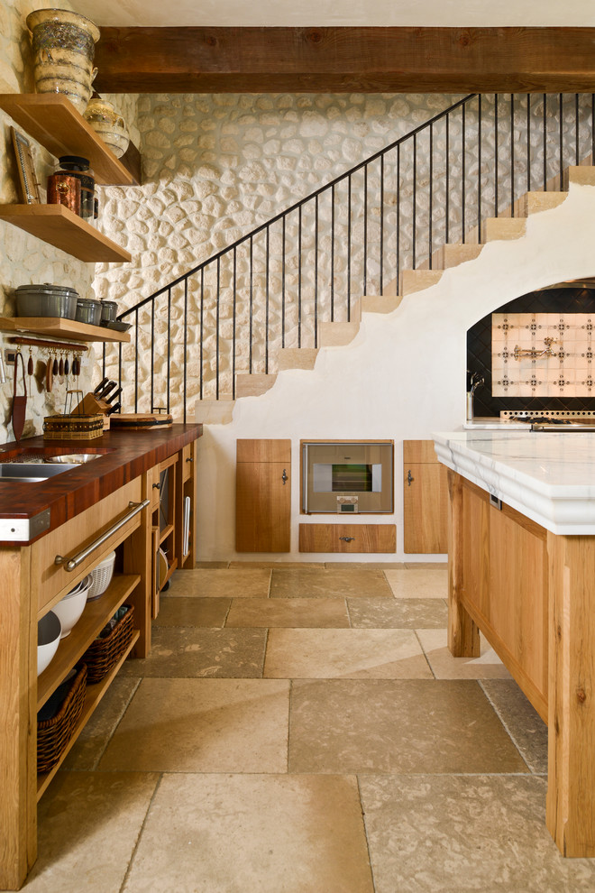 Стильный дизайн: кухня в средиземноморском стиле с светлыми деревянными фасадами и техникой из нержавеющей стали - последний тренд