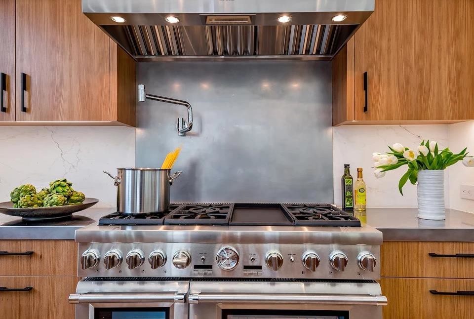 Example of a large minimalist u-shaped light wood floor and brown floor eat-in kitchen design in San Francisco with an undermount sink, flat-panel cabinets, medium tone wood cabinets, quartz countertops, white backsplash, stone slab backsplash, stainless steel appliances, an island and white countertops