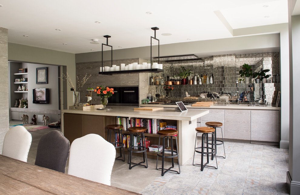 Medium sized contemporary single-wall kitchen/diner in London with a submerged sink, flat-panel cabinets, grey cabinets, limestone worktops, mirror splashback, integrated appliances, a breakfast bar and grey floors.