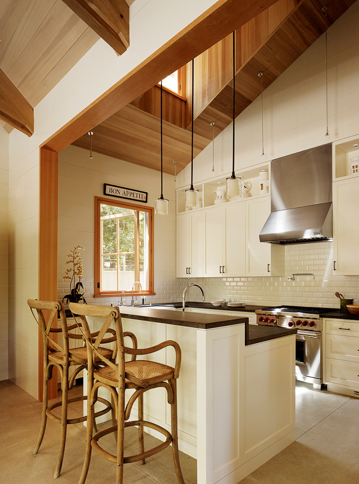 Photo of a traditional kitchen in San Francisco with shaker cabinets, beige cabinets, beige splashback, metro tiled splashback and stainless steel appliances.