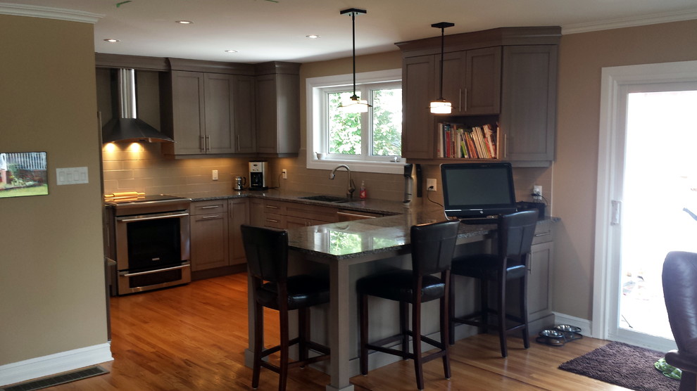 Inspiration for a large transitional u-shaped light wood floor open concept kitchen remodel in Toronto with an undermount sink, shaker cabinets, gray cabinets, quartz countertops, beige backsplash, subway tile backsplash, stainless steel appliances and a peninsula