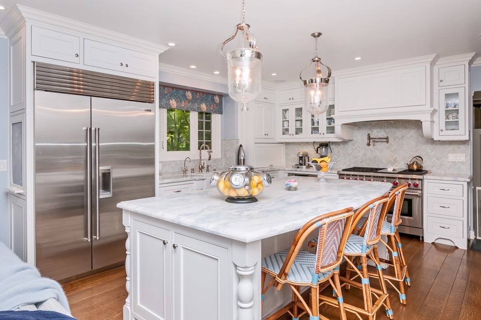 Klassische Küche in L-Form mit Glasfronten, weißen Schränken, Küchenrückwand in Grau, Küchengeräten aus Edelstahl, braunem Holzboden und Kücheninsel in San Francisco