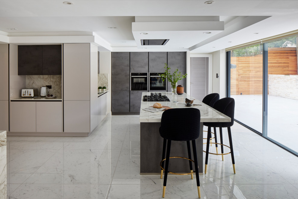 Modern inredning av ett stort grå grått kök, med släta luckor, grå skåp, marmorbänkskiva, grått stänkskydd, stänkskydd i marmor, svarta vitvaror, marmorgolv, en köksö och grått golv