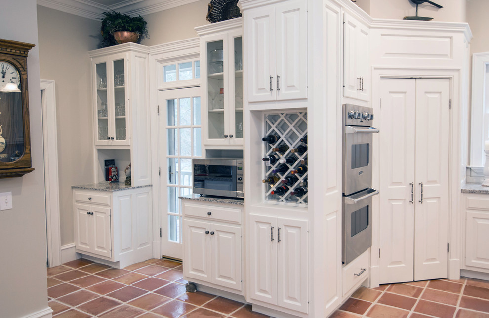 Inspiration for a medium sized classic u-shaped kitchen pantry in Atlanta with a single-bowl sink, raised-panel cabinets, white cabinets, granite worktops, white splashback, stone tiled splashback, stainless steel appliances, terracotta flooring and an island.