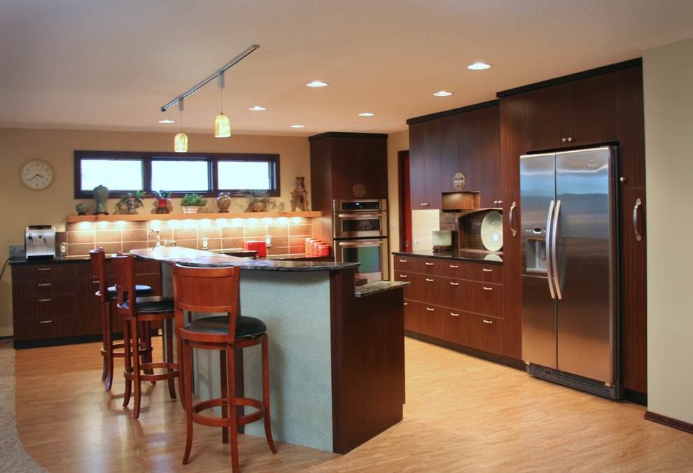 Example of a large zen l-shaped light wood floor eat-in kitchen design in Portland with an undermount sink, flat-panel cabinets, dark wood cabinets, granite countertops, metallic backsplash, porcelain backsplash, stainless steel appliances and an island