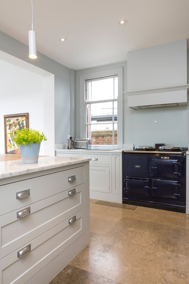 This is an example of a large contemporary u-shaped open plan kitchen in Oxfordshire with a belfast sink, shaker cabinets, grey cabinets, composite countertops, white splashback, integrated appliances, ceramic flooring and an island.