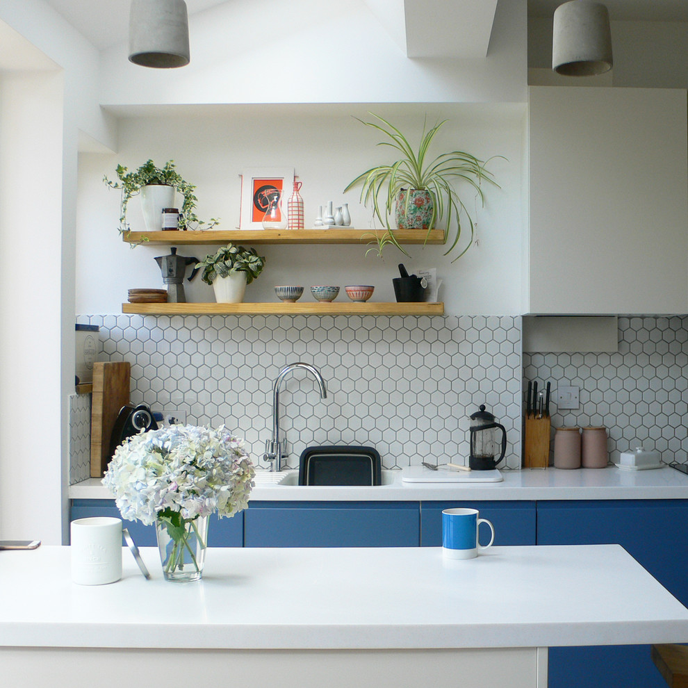 Foto de cocina actual de tamaño medio con fregadero de un seno, armarios con paneles lisos, puertas de armario azules, salpicadero blanco y encimeras blancas