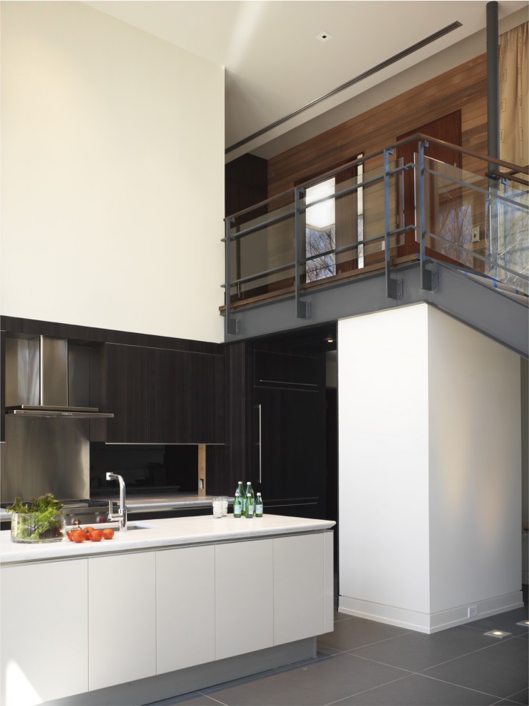 Modelo de cocina contemporánea abierta con armarios con paneles lisos, puertas de armario de madera en tonos medios, salpicadero metalizado y salpicadero de metal