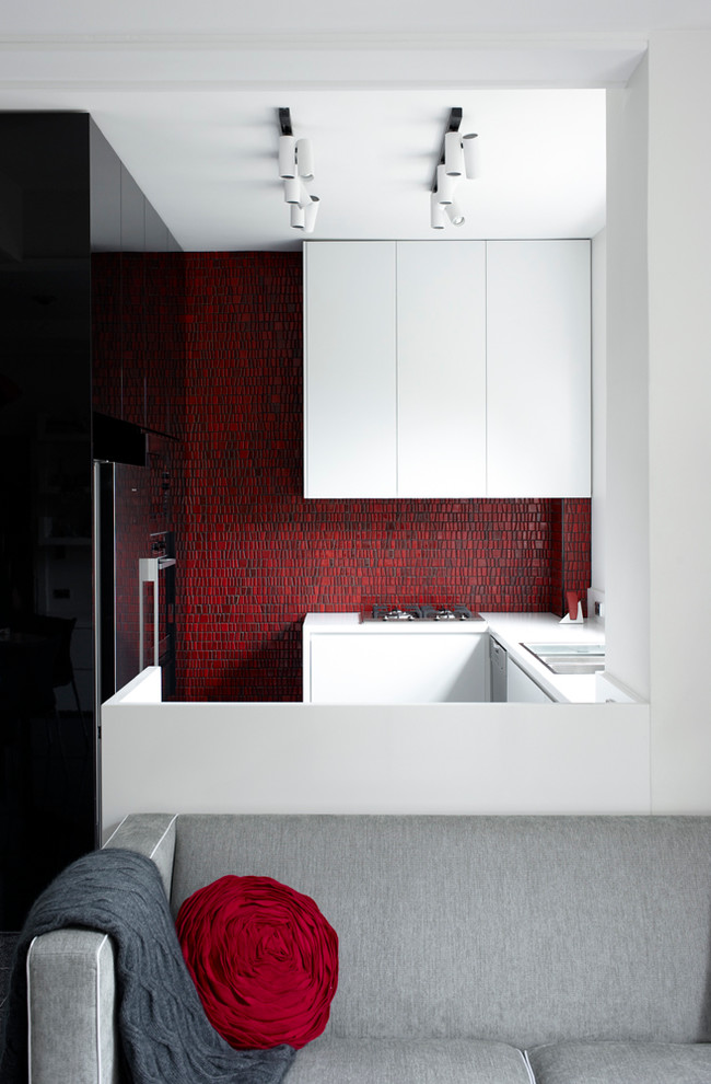This is an example of a medium sized contemporary u-shaped kitchen in Sydney with an integrated sink, white cabinets, engineered stone countertops, red splashback, mosaic tiled splashback, stainless steel appliances, marble flooring and an island.