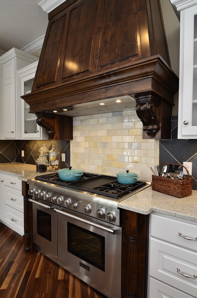 Aménagement d'une cuisine classique avec un électroménager en acier inoxydable et un plan de travail en granite.
