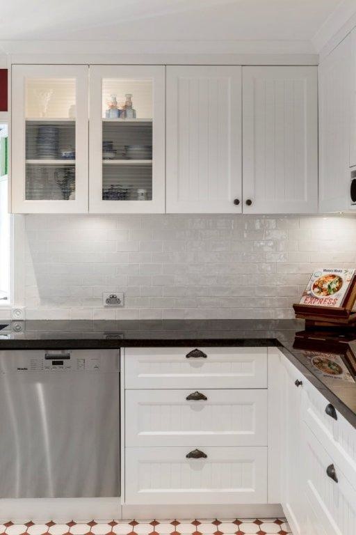 Inspiration for a medium sized traditional u-shaped kitchen/diner in Brisbane with a belfast sink, recessed-panel cabinets, white cabinets, granite worktops, white splashback, metro tiled splashback, stainless steel appliances, ceramic flooring and an island.