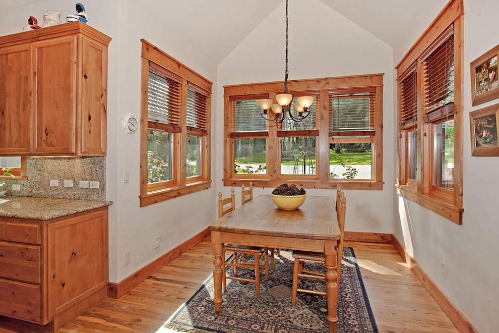 Immagine di una cucina abitabile american style con ante con bugna sagomata, ante in legno chiaro, top in granito, paraspruzzi beige, paraspruzzi in lastra di pietra e parquet chiaro