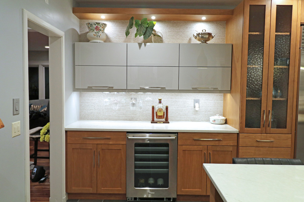 Inredning av ett modernt stort vit vitt kök, med en undermonterad diskho, skåp i shakerstil, skåp i mellenmörkt trä, bänkskiva i kvarts, beige stänkskydd, stänkskydd i porslinskakel, rostfria vitvaror, klinkergolv i porslin, en köksö och grått golv