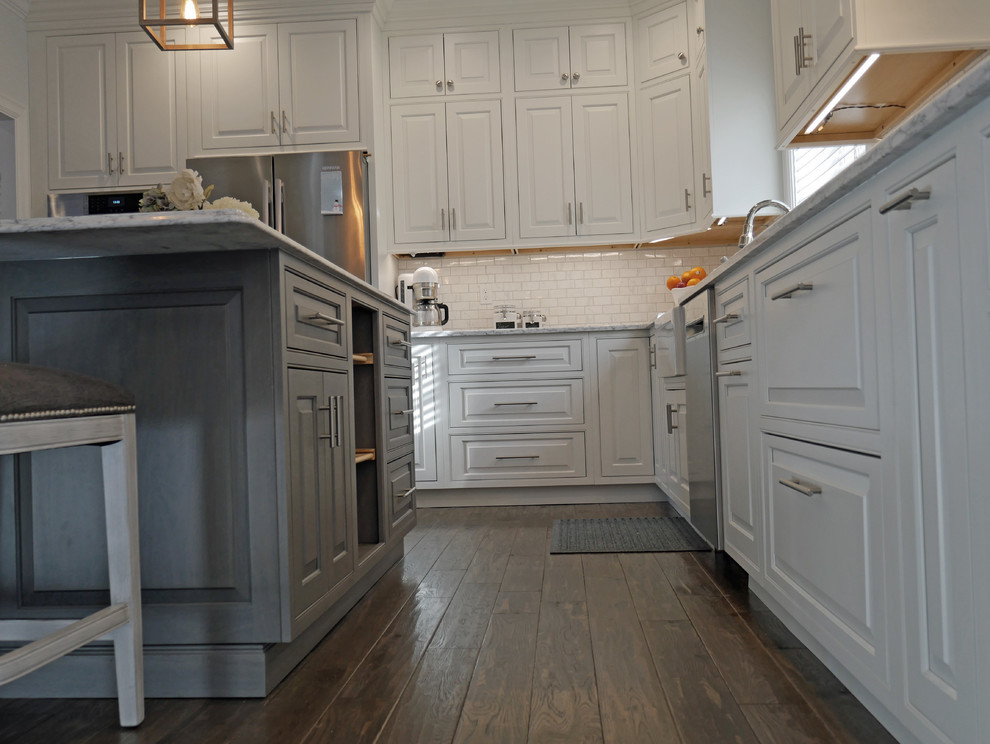 Bild på ett mellanstort vintage kök, med en rustik diskho, luckor med profilerade fronter, vita skåp, bänkskiva i kvarts, vitt stänkskydd, stänkskydd i porslinskakel, rostfria vitvaror, mörkt trägolv, en köksö och brunt golv