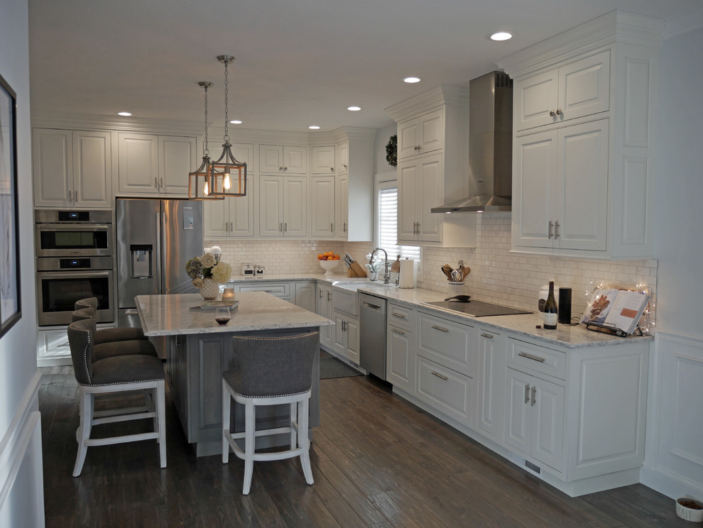 Exempel på ett mellanstort klassiskt kök, med en rustik diskho, luckor med profilerade fronter, vita skåp, bänkskiva i kvarts, vitt stänkskydd, stänkskydd i porslinskakel, rostfria vitvaror, mörkt trägolv, en köksö och brunt golv