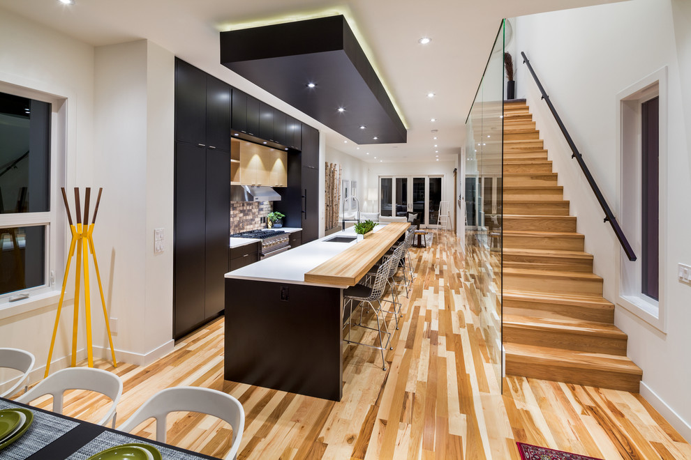 Esempio di una cucina contemporanea con lavello sottopiano, ante lisce, ante nere e pavimento in legno massello medio
