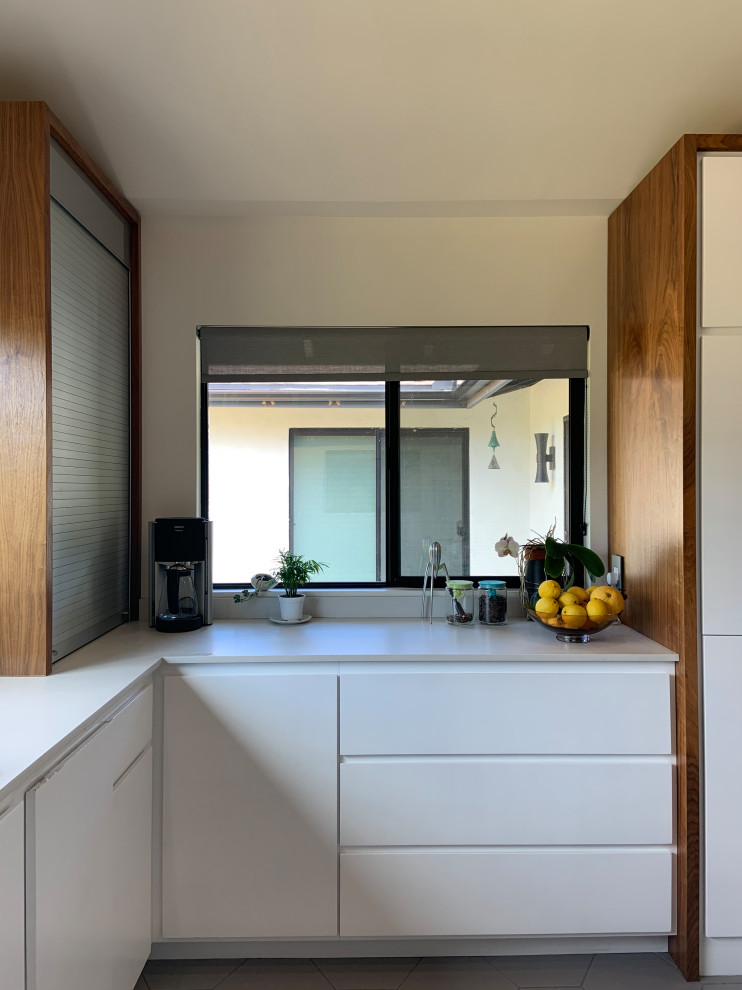 Open concept kitchen - mid-sized 1950s l-shaped porcelain tile, gray floor and vaulted ceiling open concept kitchen idea in San Diego with an undermount sink, flat-panel cabinets, white cabinets, quartz countertops, white backsplash, quartz backsplash, stainless steel appliances, an island and white countertops