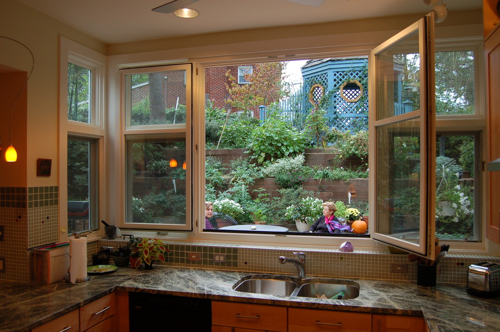 Inspiration för mellanstora moderna grönt kök, med en undermonterad diskho, granitbänkskiva, stänkskydd i glaskakel, rostfria vitvaror, korkgolv, en halv köksö, skåp i shakerstil, skåp i ljust trä, grönt stänkskydd och brunt golv