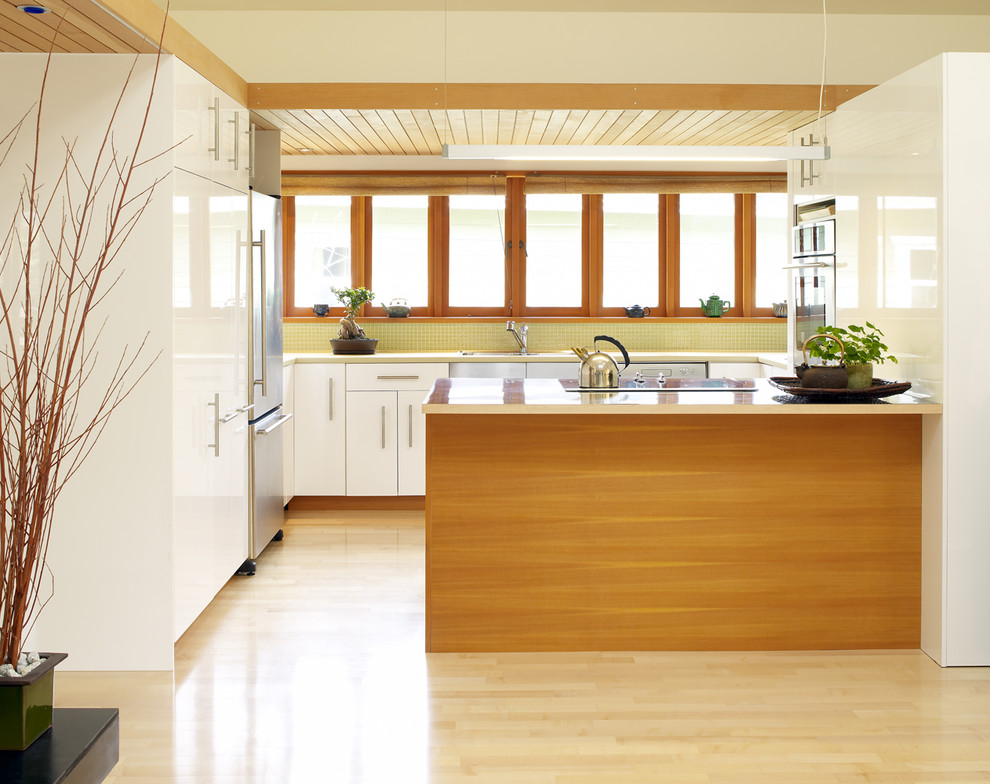 Minimalist kitchen photo in Vancouver with mosaic tile backsplash, stainless steel appliances, flat-panel cabinets, white cabinets and yellow backsplash