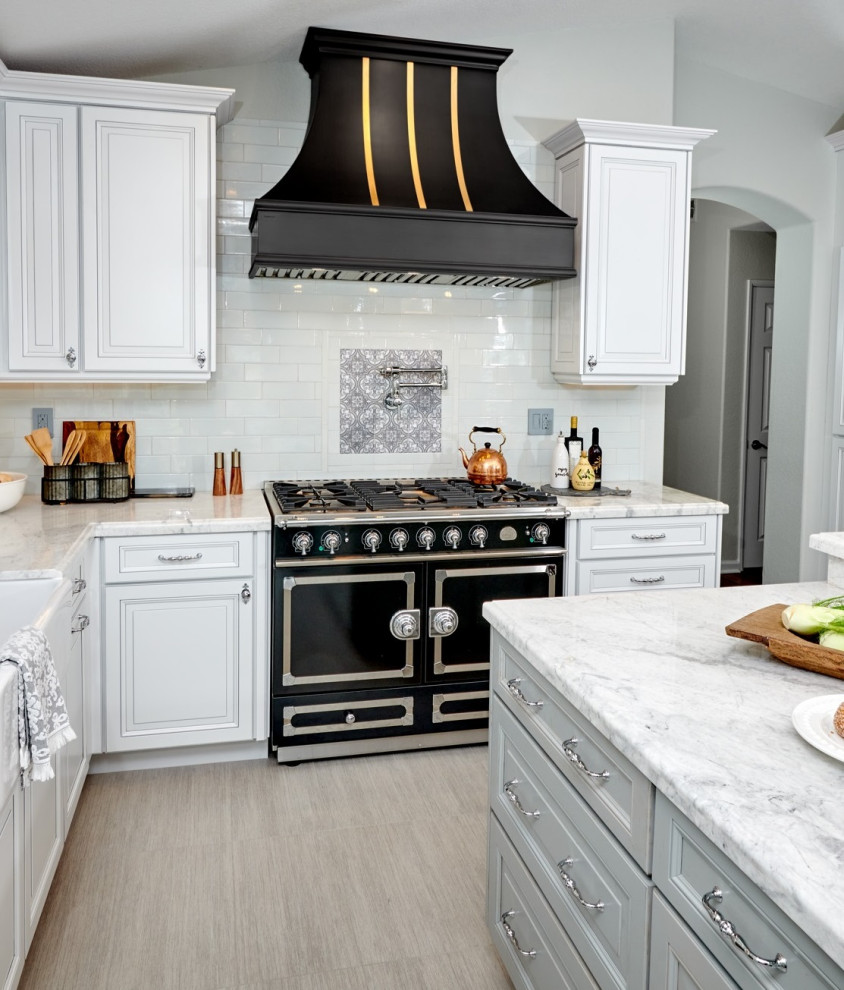 Inspiration for a mid-sized timeless u-shaped terra-cotta tile and gray floor open concept kitchen remodel in Denver with a farmhouse sink, raised-panel cabinets, white cabinets, marble countertops, gray backsplash, ceramic backsplash, black appliances, an island and white countertops