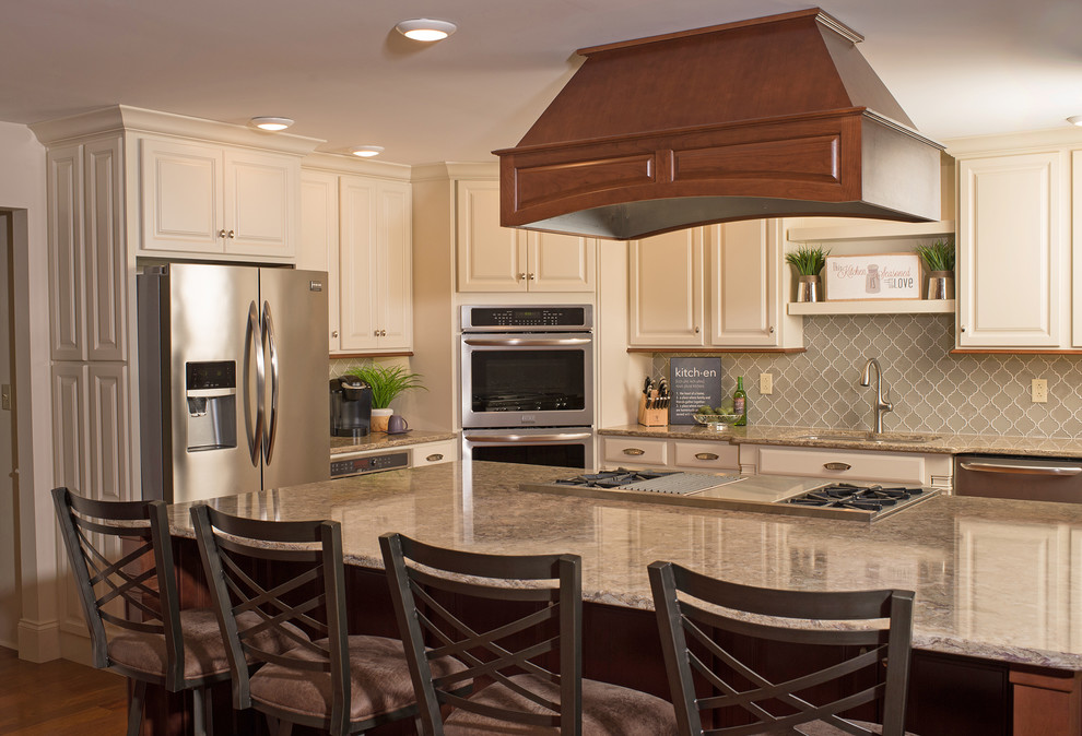 Mid-sized transitional l-shaped medium tone wood floor eat-in kitchen photo in Philadelphia with an undermount sink, raised-panel cabinets, white cabinets, quartz countertops, gray backsplash, glass tile backsplash, stainless steel appliances and an island