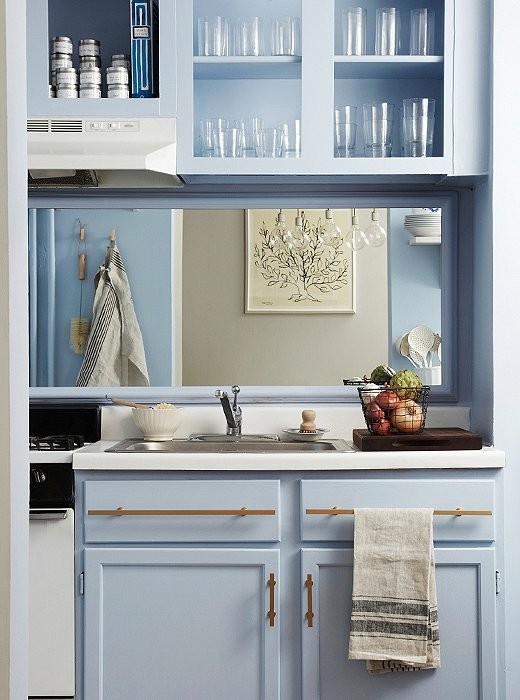Inspiration för avskilda, små amerikanska linjära kök, med en nedsänkt diskho, skåp i shakerstil, blå skåp, laminatbänkskiva, stänkskydd med metallisk yta, spegel som stänkskydd och vita vitvaror