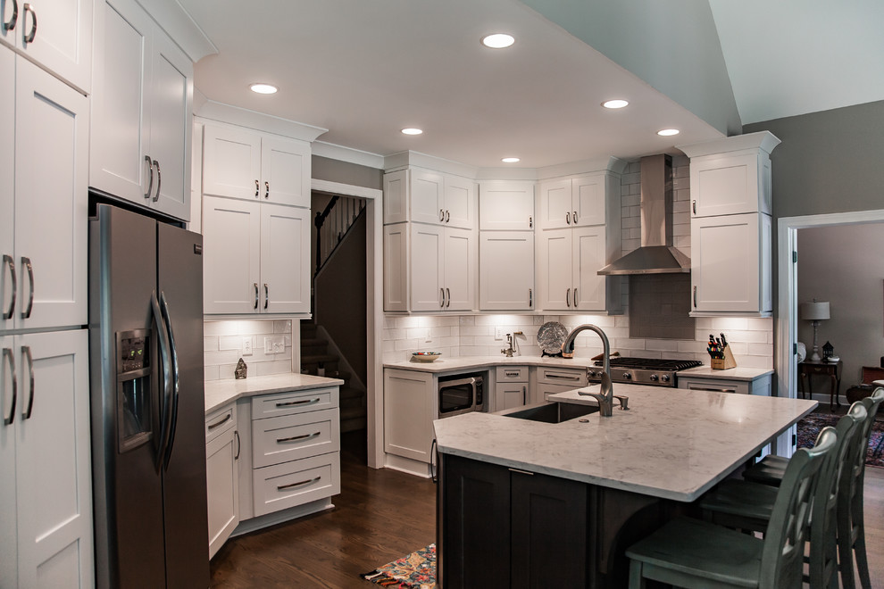Example of a huge trendy u-shaped medium tone wood floor and brown floor open concept kitchen design in Atlanta with a farmhouse sink, shaker cabinets, white cabinets, quartz countertops, white backsplash, ceramic backsplash, stainless steel appliances, an island and yellow countertops