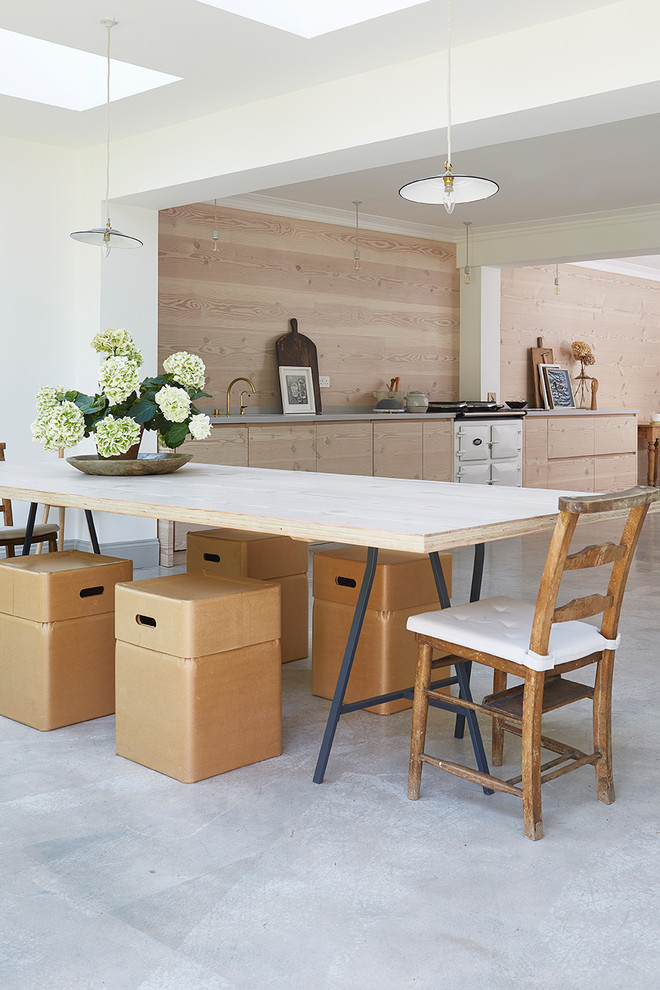 Inspiration for a large scandi open plan kitchen in London with flat-panel cabinets, light wood cabinets, composite countertops, concrete flooring and an island.