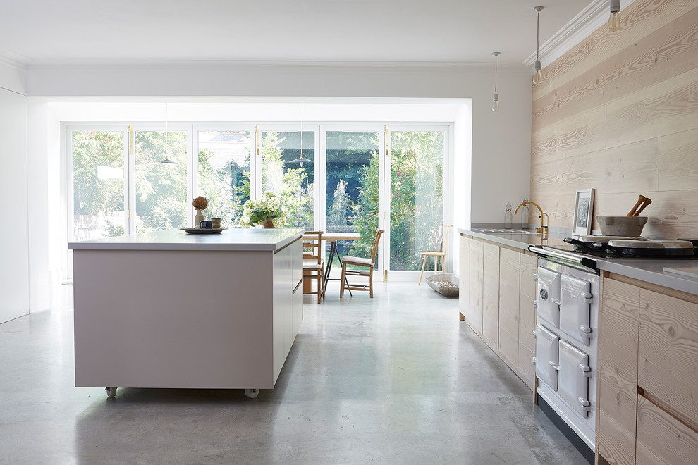Foto di una grande cucina scandinava con lavello integrato, ante lisce, ante in legno chiaro, top in superficie solida e pavimento in cemento