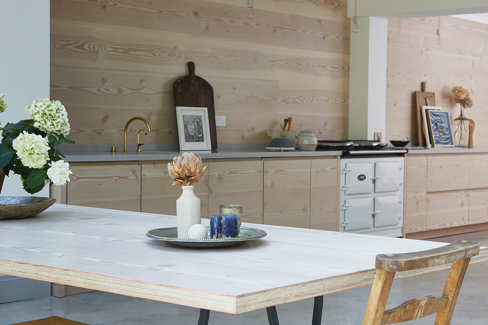 Esempio di una grande cucina scandinava con lavello integrato, ante lisce, ante in legno chiaro, top in superficie solida e pavimento in cemento