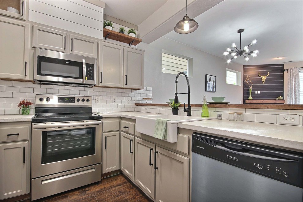 Example of a small eclectic u-shaped laminate floor and brown floor kitchen design in Seattle with a farmhouse sink, beige cabinets, concrete countertops, white backsplash and subway tile backsplash