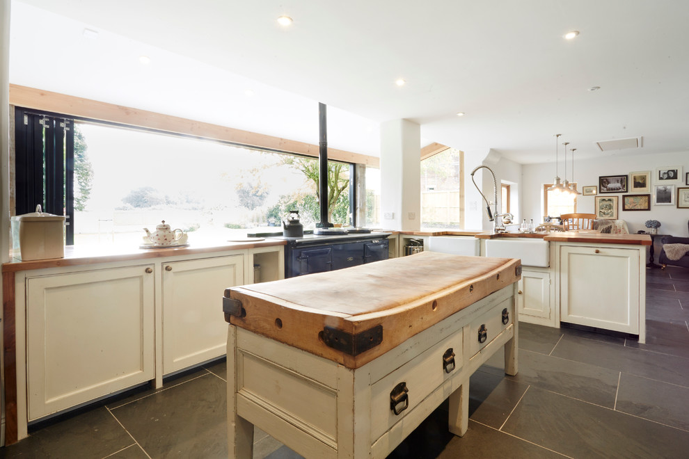 Inspiration for a large country l-shaped kitchen/diner in Wiltshire with a belfast sink, open cabinets, white cabinets, wood worktops, integrated appliances, porcelain flooring and no island.