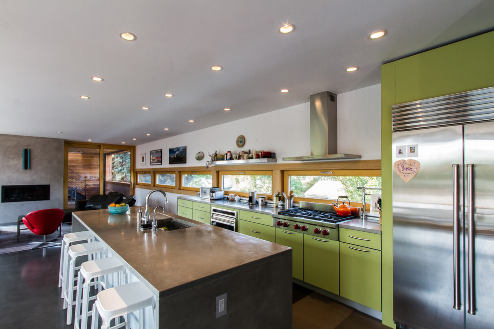 Foto di una cucina contemporanea con ante lisce, ante verdi, top in cemento e elettrodomestici in acciaio inossidabile