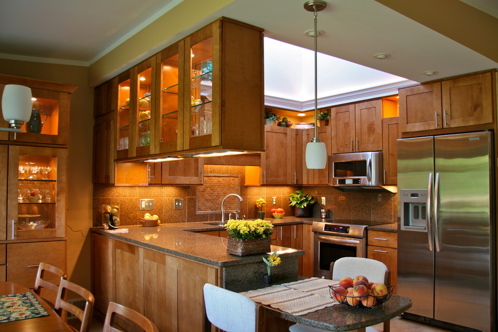 Example of a mid-sized eclectic u-shaped porcelain tile eat-in kitchen design in Other with an undermount sink, medium tone wood cabinets, granite countertops, brown backsplash, stone tile backsplash, stainless steel appliances, a peninsula and shaker cabinets