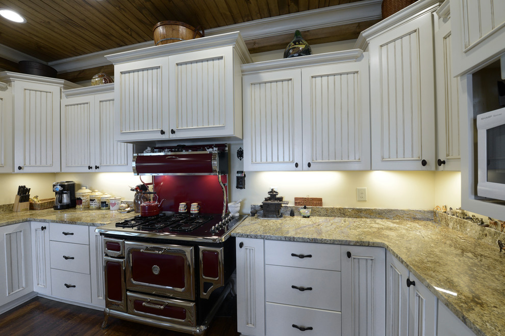 Eat-in kitchen - large country u-shaped dark wood floor eat-in kitchen idea in Birmingham with a farmhouse sink, shaker cabinets, white cabinets, granite countertops, beige backsplash, stone slab backsplash, colored appliances and an island